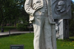VI Lenin standing, resting hand on pillar