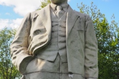 VI Lenin standing, resting hand on pillar