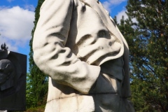 VI Lenin standing, resting hand on pillar
